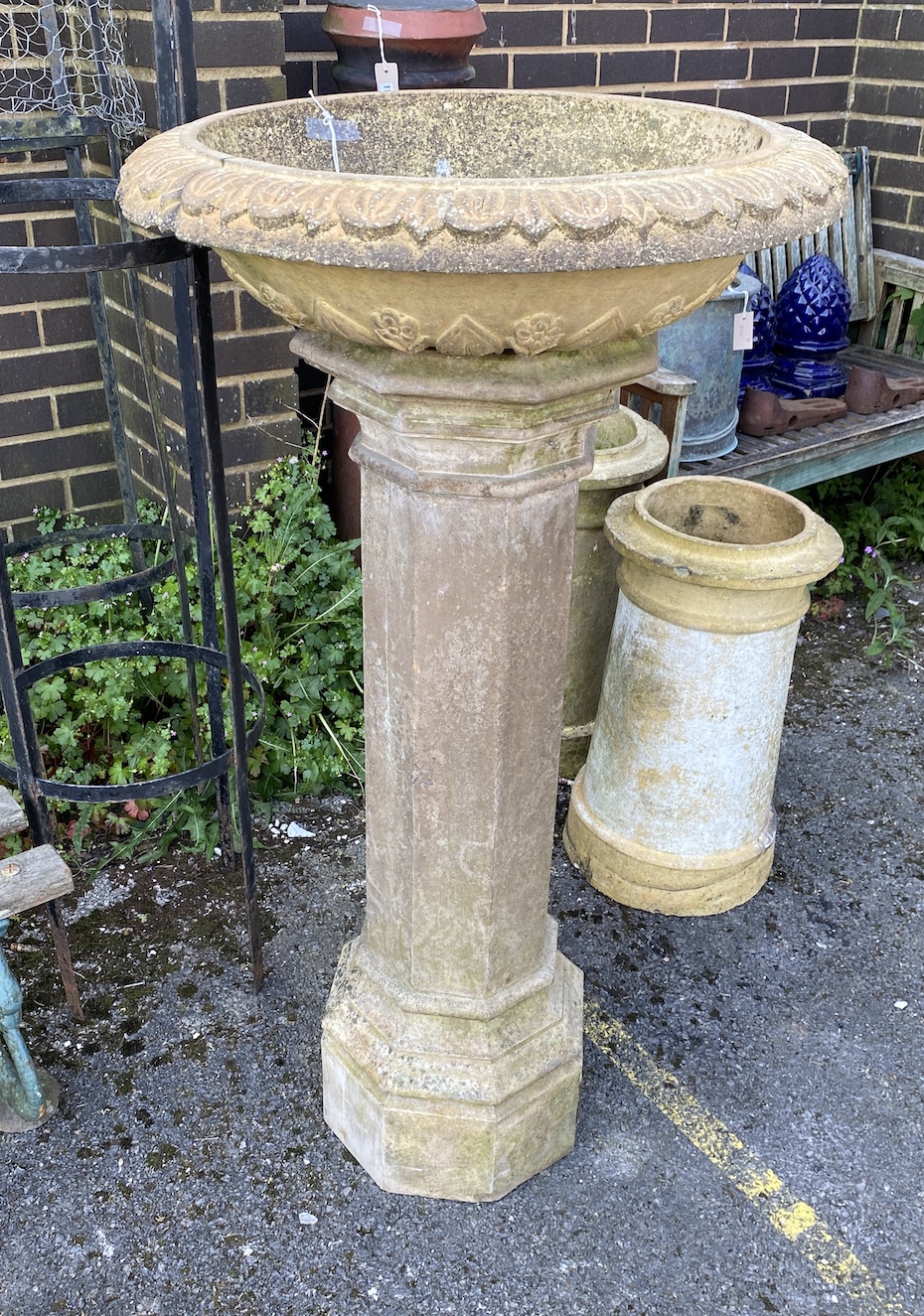 A circular stone planter on octagonal column, height 118cm